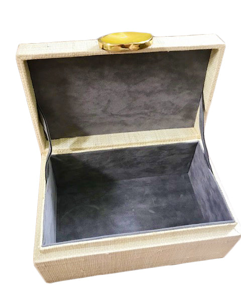 Karuna Raffia Jewelry Box, handcrafted from 100% natural raffia with a polished agate stone accent and hand-tooled brass detailing. Elegant, eco-friendly storage for jewelry and keepsakes.