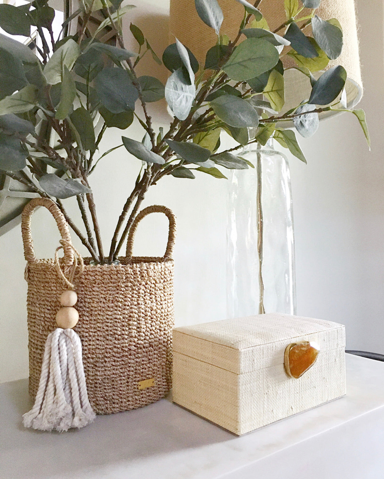 Karuna Raffia Jewelry Box, handcrafted from 100% natural raffia with a polished agate stone accent and hand-tooled brass detailing. Elegant, eco-friendly storage for jewelry and keepsakes.